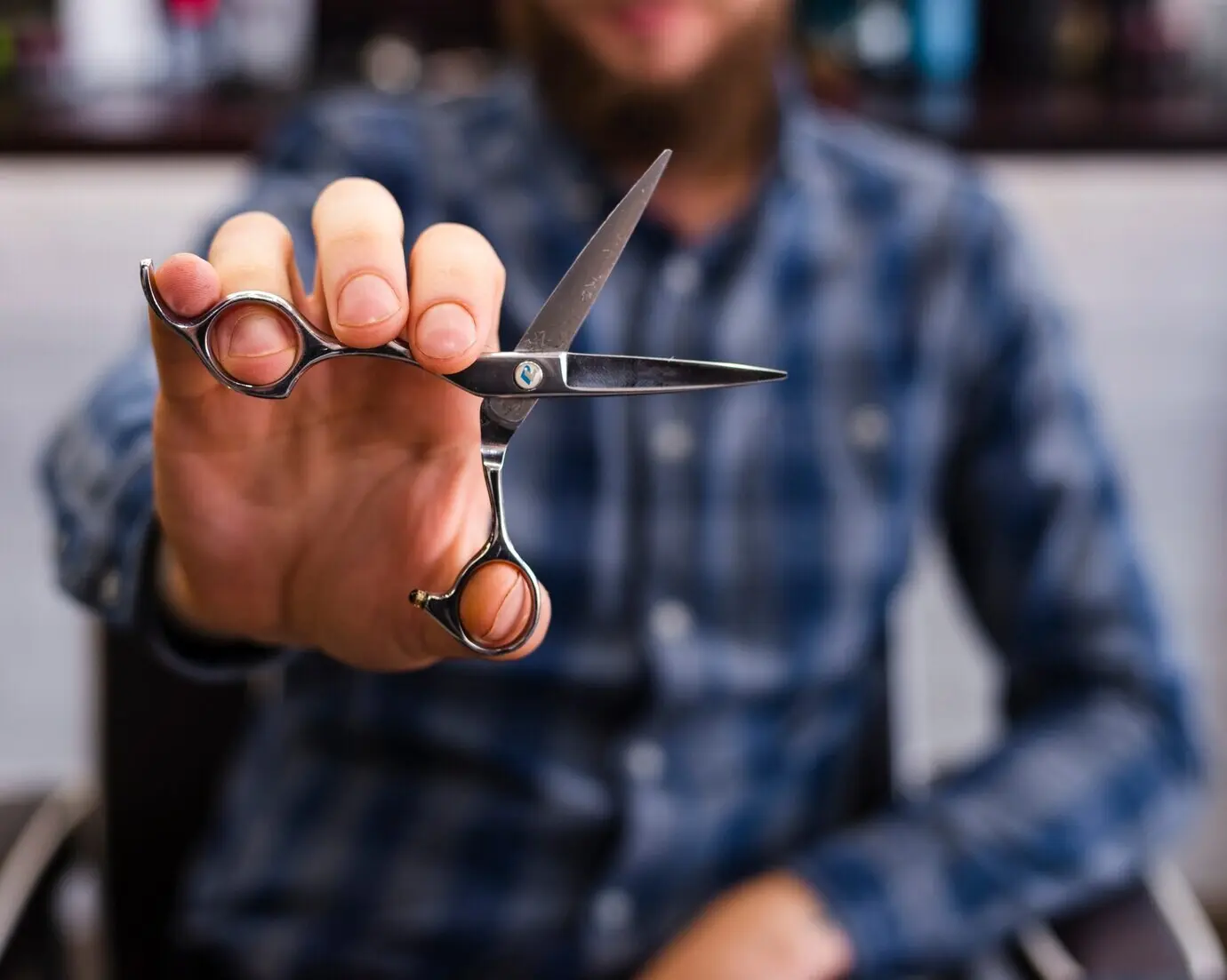 Close-up of a man displaying scissors.