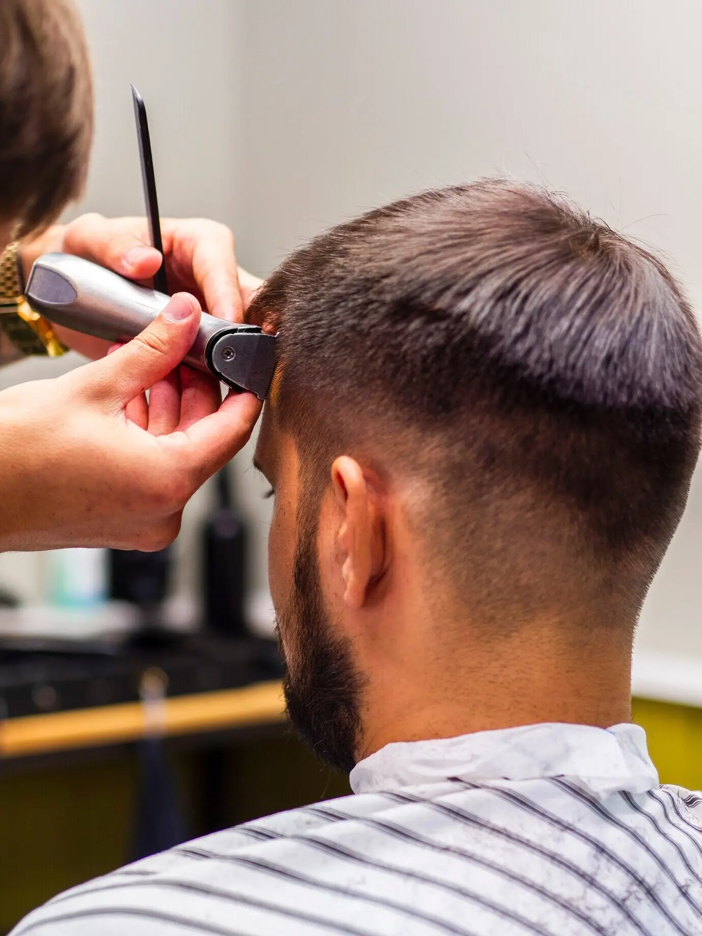A man getting a hair trim from behind.