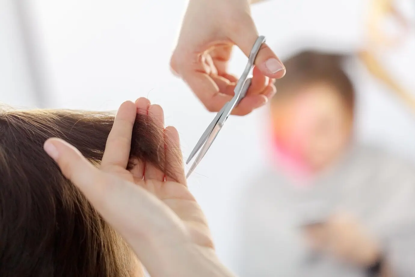 A woman performing a haircut.